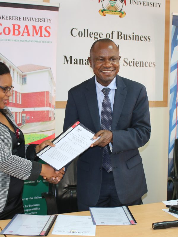 Ms. Kukunda (Left) and Prof. Hisali (Centre) exchange the agreements and Prof. Akileng (Right) looks on.