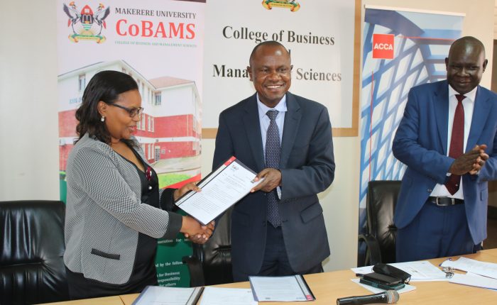 Ms. Kukunda (Left) and Prof. Hisali (Centre) exchange the agreements and Prof. Akileng (Right) looks on.
